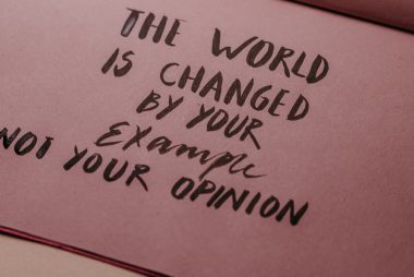 Motivational phrase emphasizing actions over words displayed on textured paper.